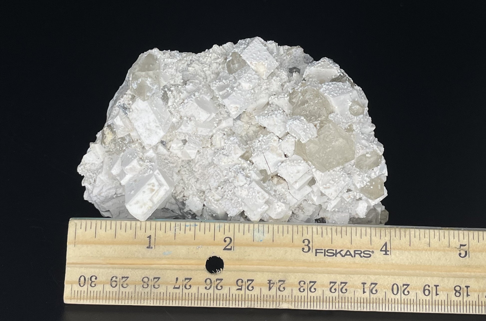 A close-up image of a mineral specimen featuring creamy Orthoclase crystals intergrown with clear quartz and dark tourmaline, showcasing a striking blend of textures and colors.