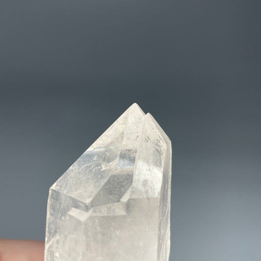 A 4.75-inch Clear Quartz double-point tower with a smooth, polished finish, standing upright against a neutral background.