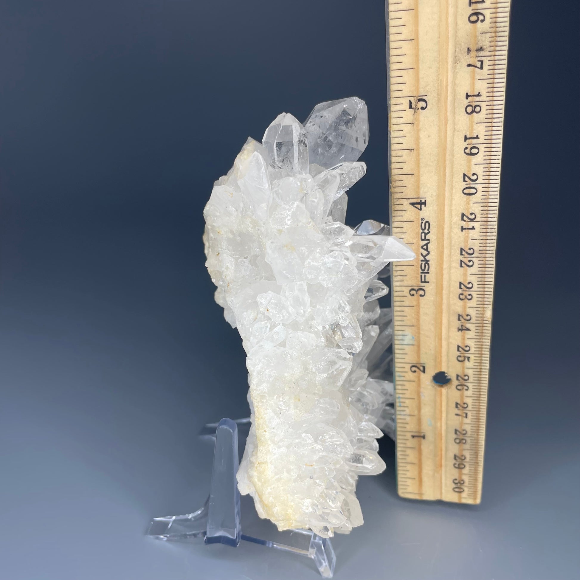 A natural Clear Quartz cluster with multiple crystal points, reflecting light beautifully against a neutral background.