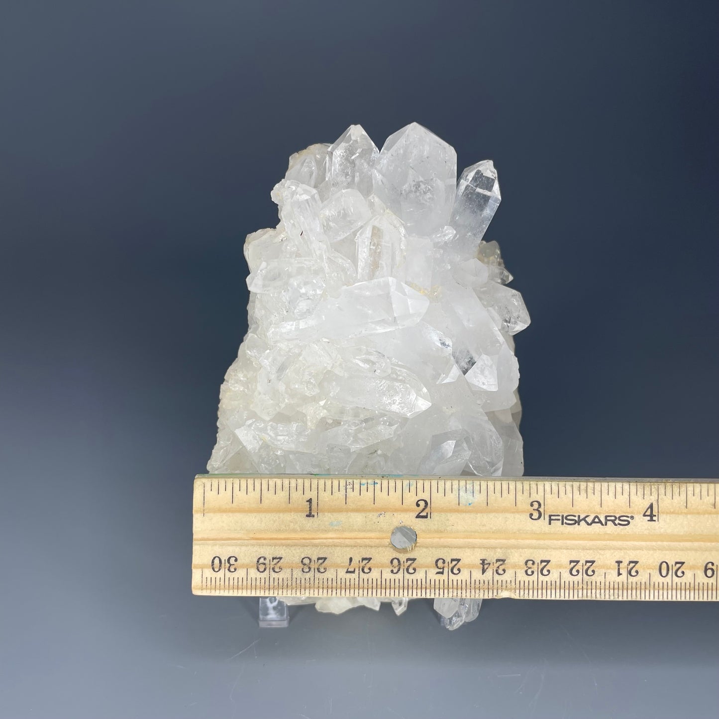 A natural Clear Quartz cluster with multiple crystal points, reflecting light beautifully against a neutral background.