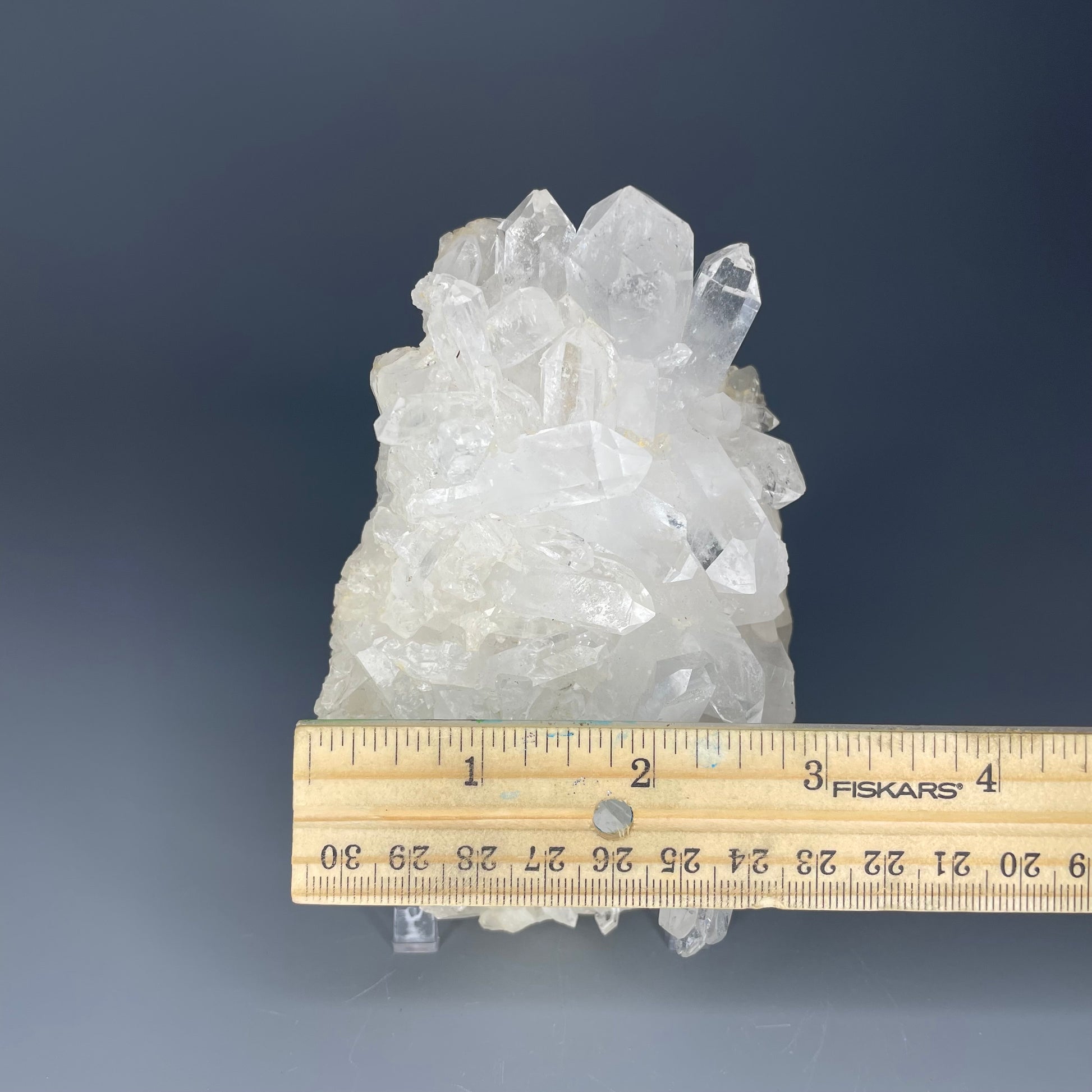 A natural Clear Quartz cluster with multiple crystal points, reflecting light beautifully against a neutral background.