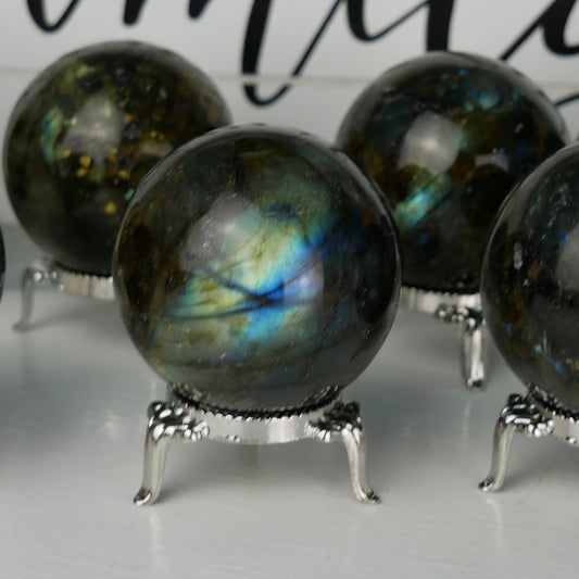 Shimmering Labradorite sphere measuring 2 inches in diameter. This sphere showcases the mesmerizing play of colors, known as labradorescence, with hues of blues, greens, and golds dancing across its surface. Perfect for collectors or as a stunning addition to any crystal display.