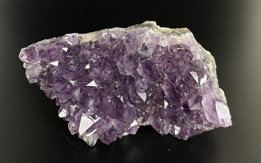 Amethyst cluster with brilliant hues of purple and various sizes of crystal formations.