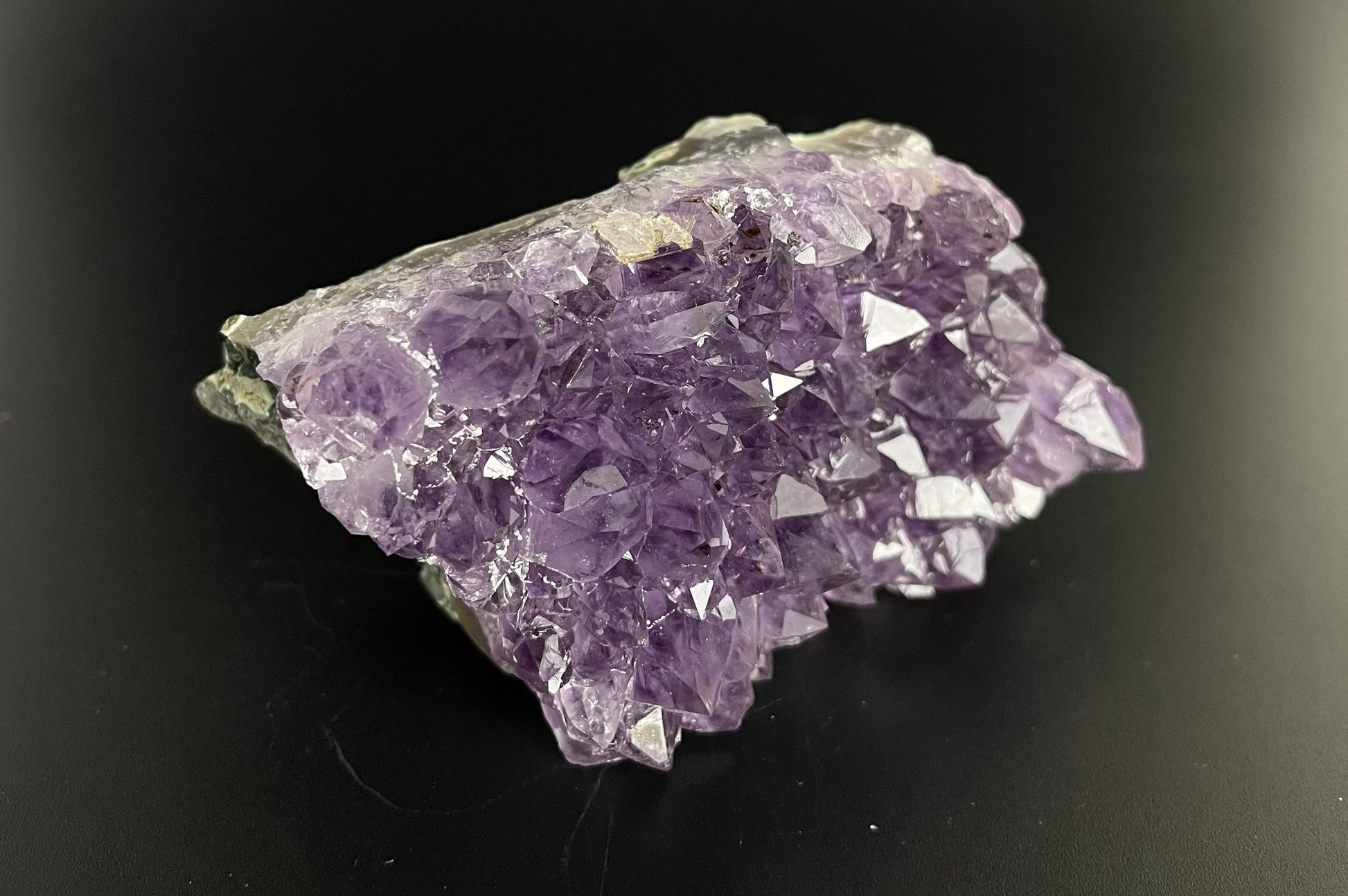 Amethyst cluster with brilliant hues of purple and various sizes of crystal formations.