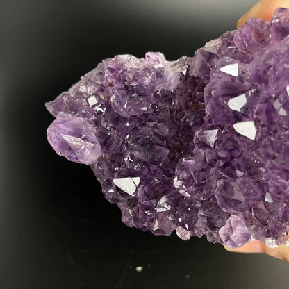 Amethyst cluster with brilliant hues of purple and various sizes of crystal formations.