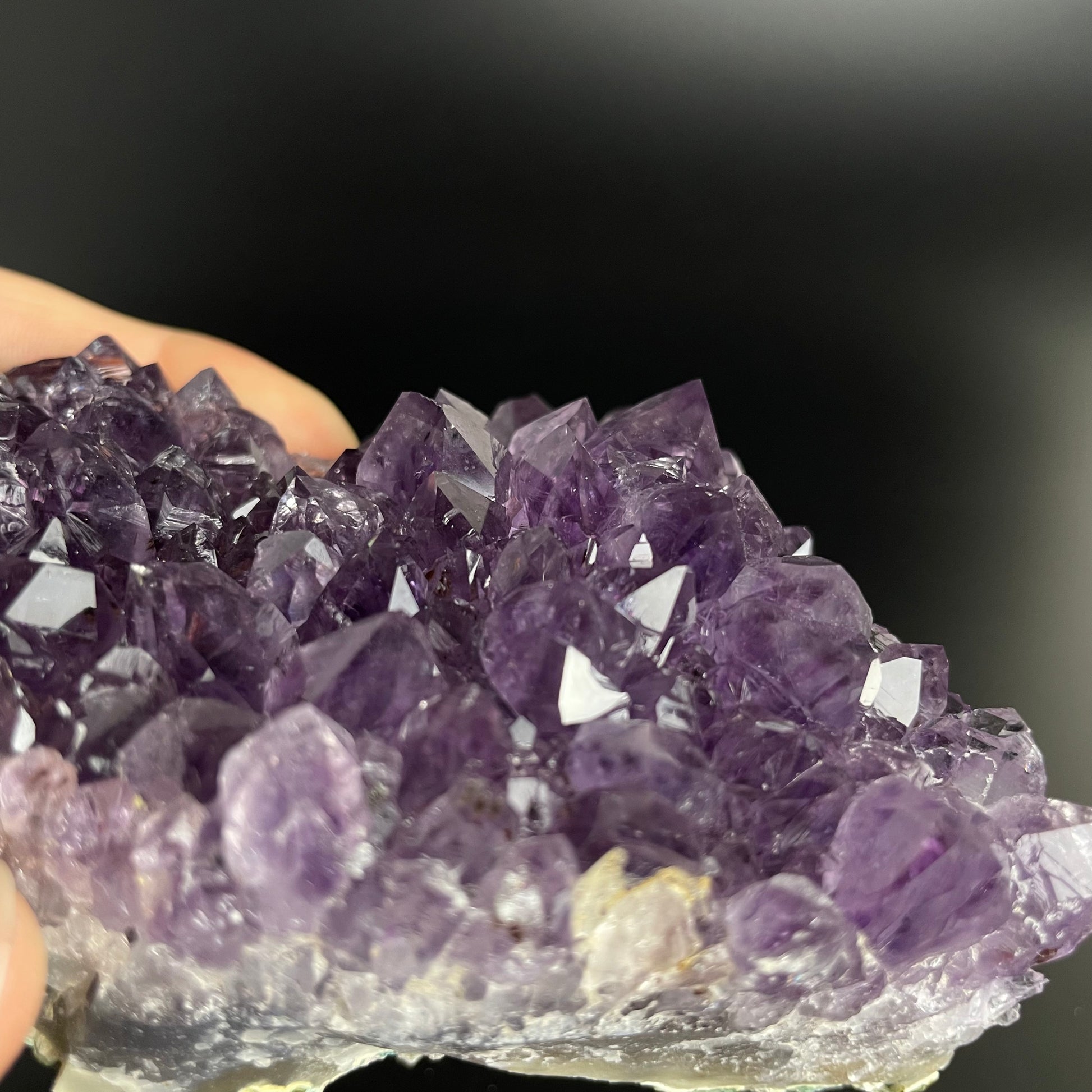 Amethyst cluster with brilliant hues of purple and various sizes of crystal formations.