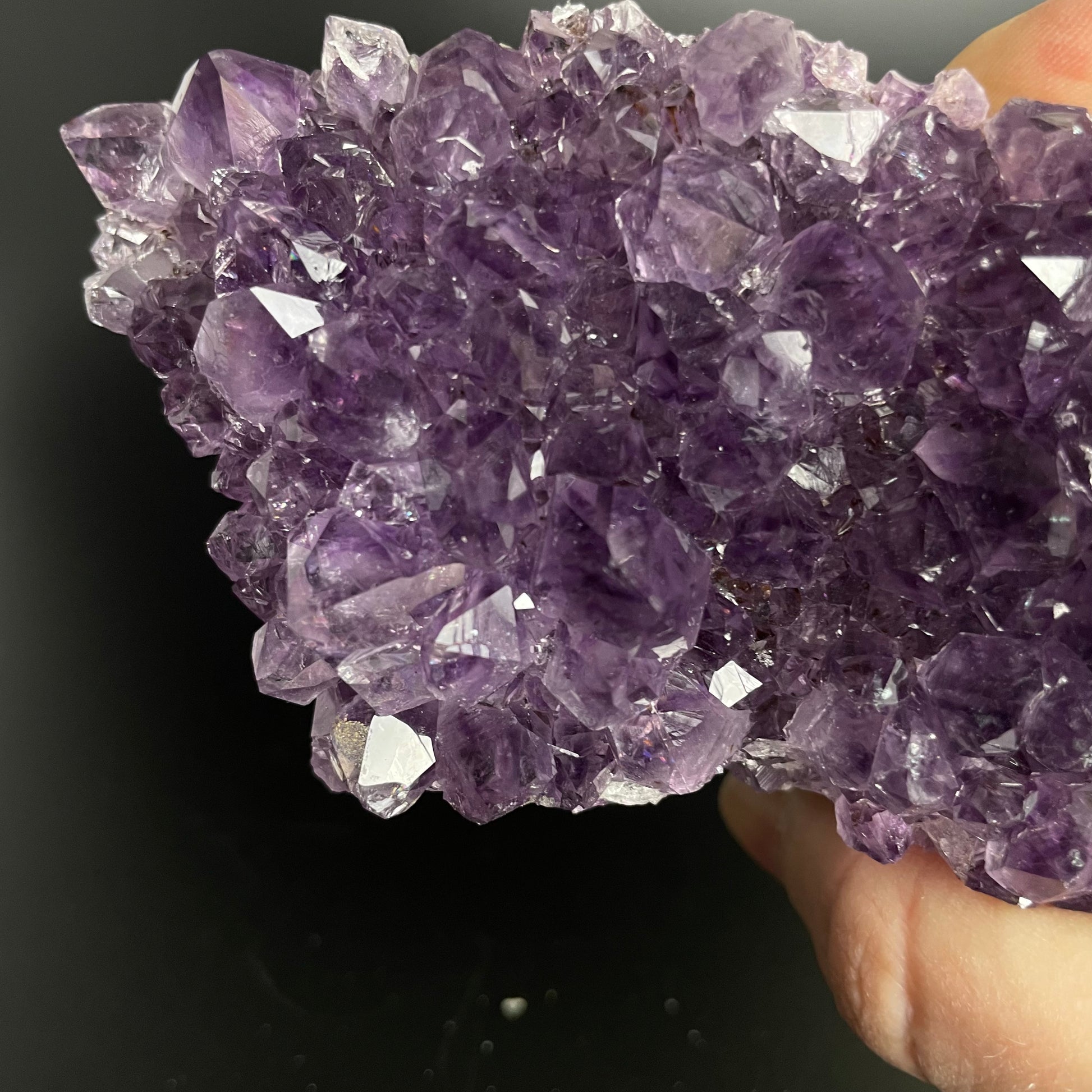 Amethyst cluster with brilliant hues of purple and various sizes of crystal formations.