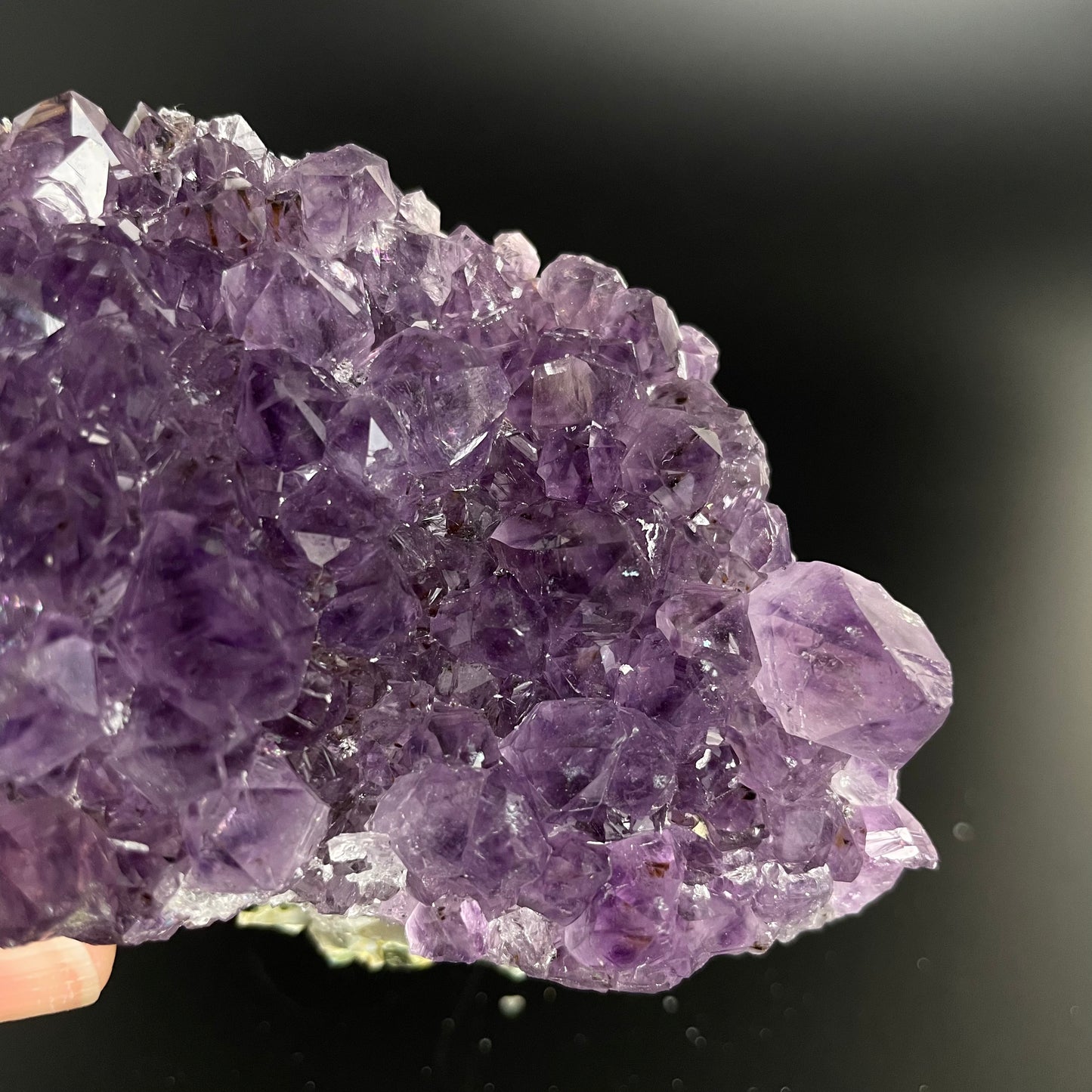 Amethyst cluster with brilliant hues of purple and various sizes of crystal formations.