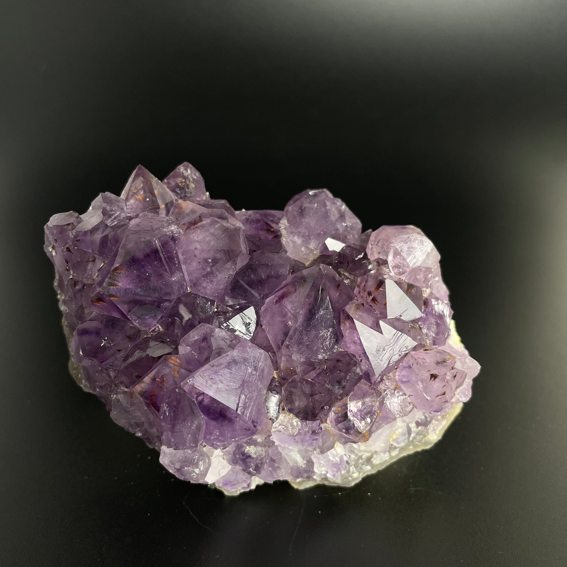 Amethyst cluster with brilliant hues of purple and various sizes of crystal formations.