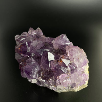 Amethyst cluster with brilliant hues of purple and various sizes of crystal formations.