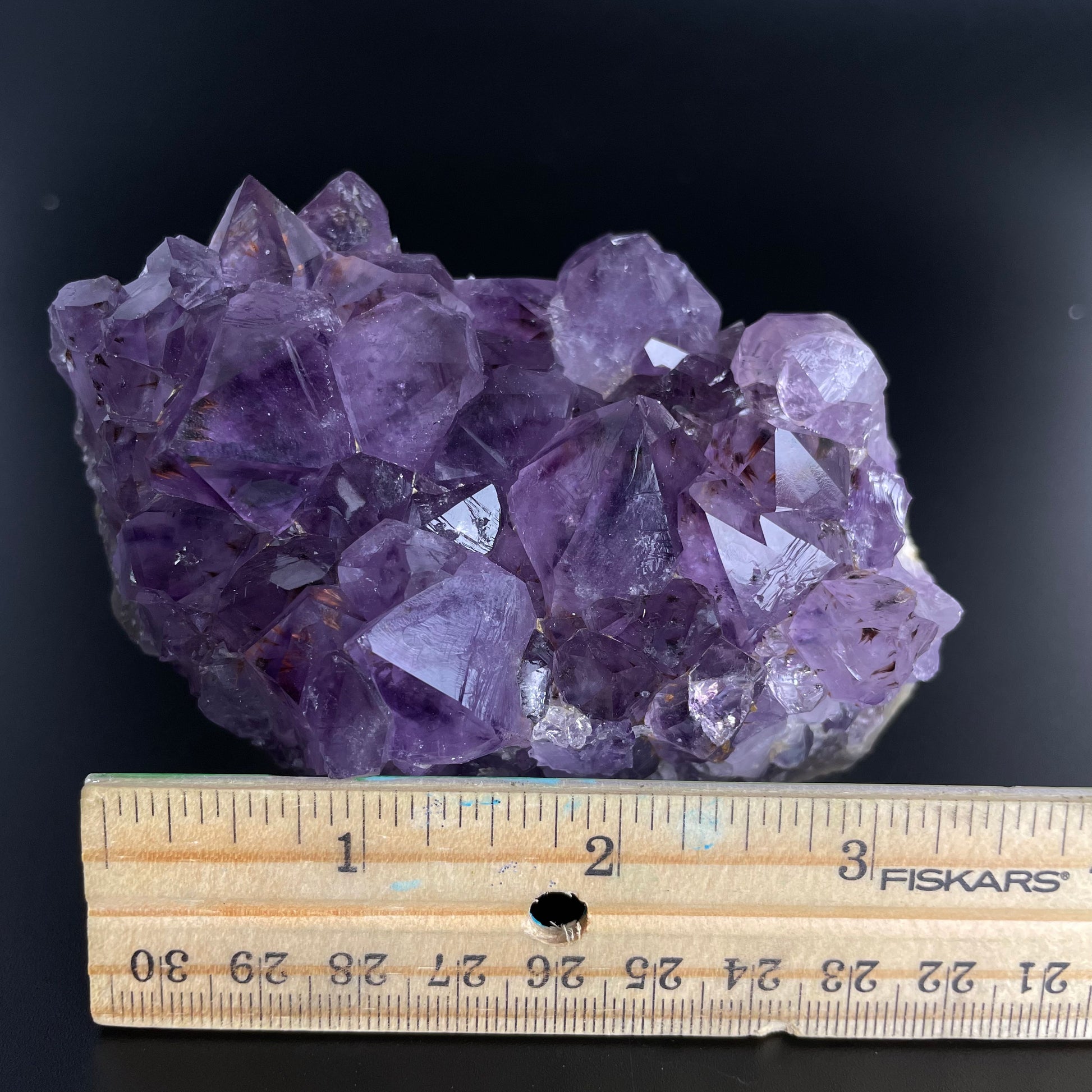 Amethyst cluster with brilliant hues of purple and various sizes of crystal formations.