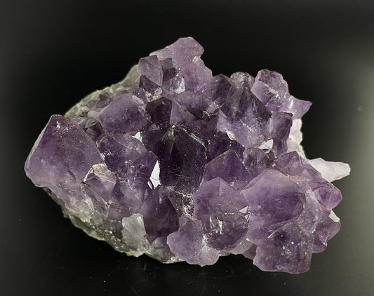 Amethyst cluster with brilliant hues of purple and various sizes of crystal formations.