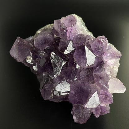 Amethyst cluster with brilliant hues of purple and various sizes of crystal formations.