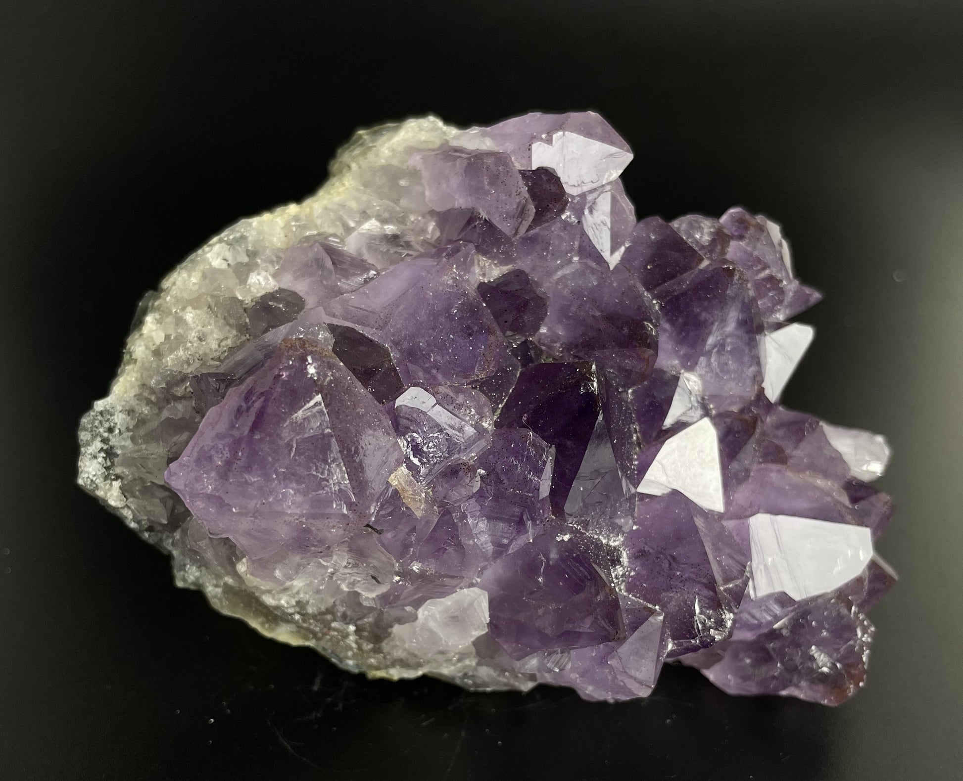 Amethyst cluster with brilliant hues of purple and various sizes of crystal formations.