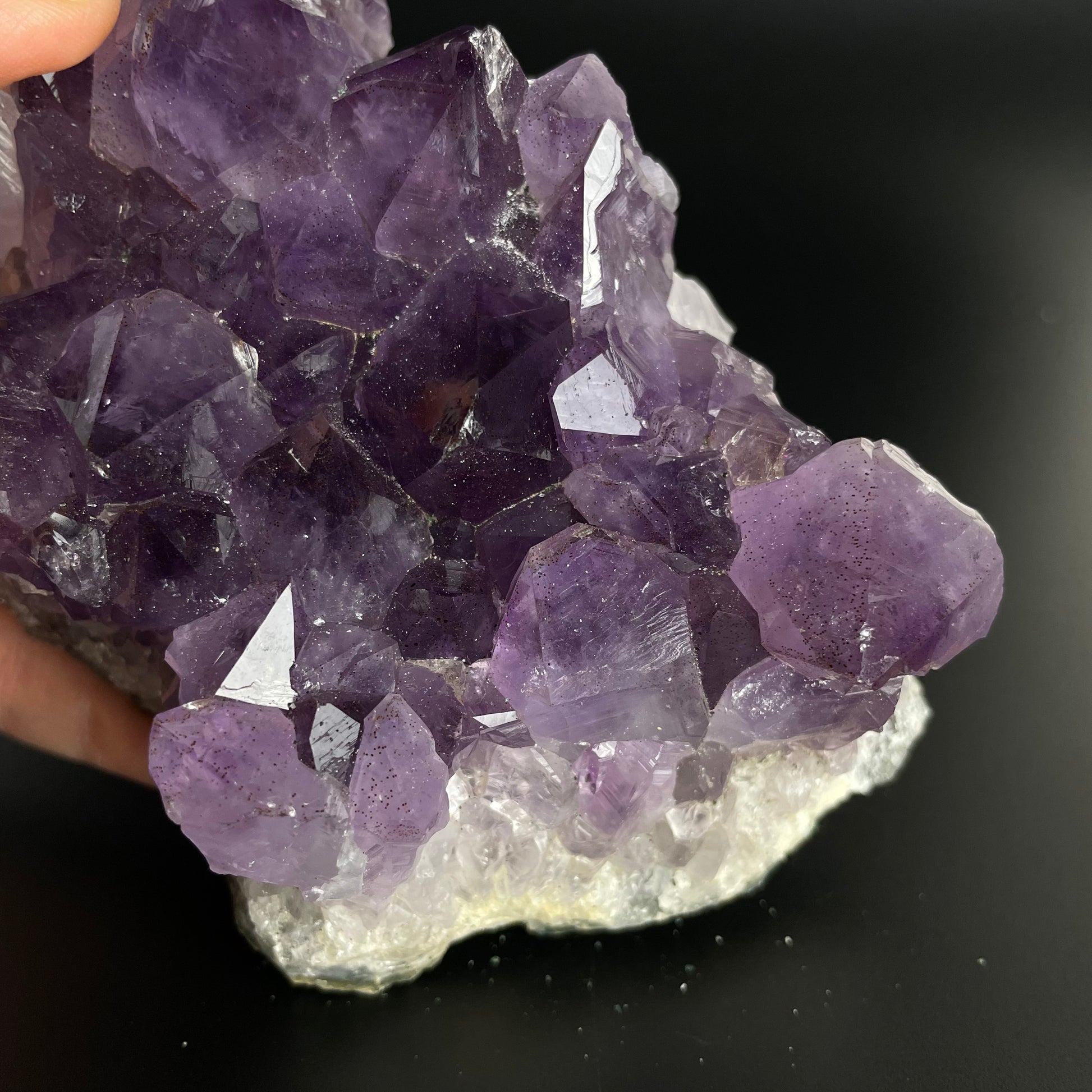 Amethyst cluster with brilliant hues of purple and various sizes of crystal formations.