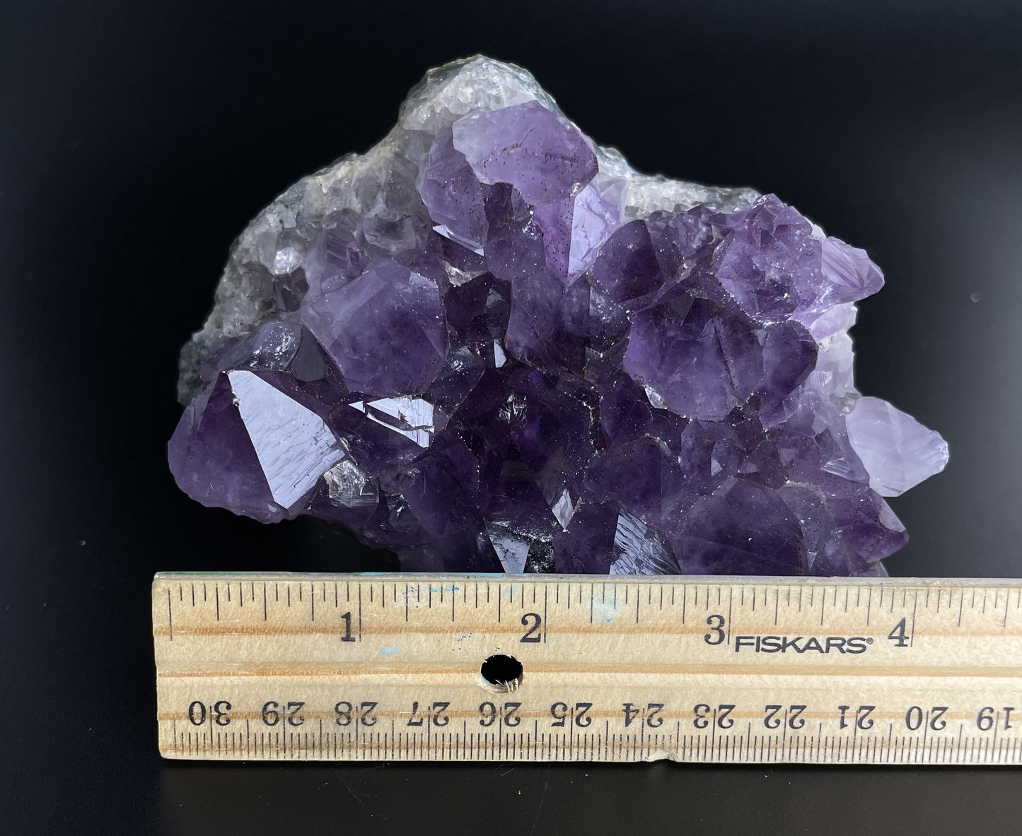 Amethyst cluster with brilliant hues of purple and various sizes of crystal formations.