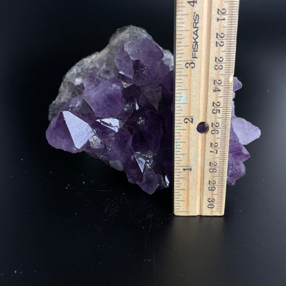 Amethyst cluster with brilliant hues of purple and various sizes of crystal formations.