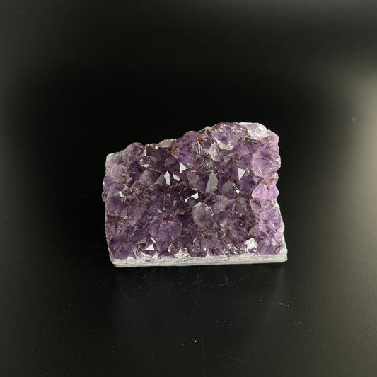 Amethyst cluster with brilliant hues of purple and various sizes of crystal formations.