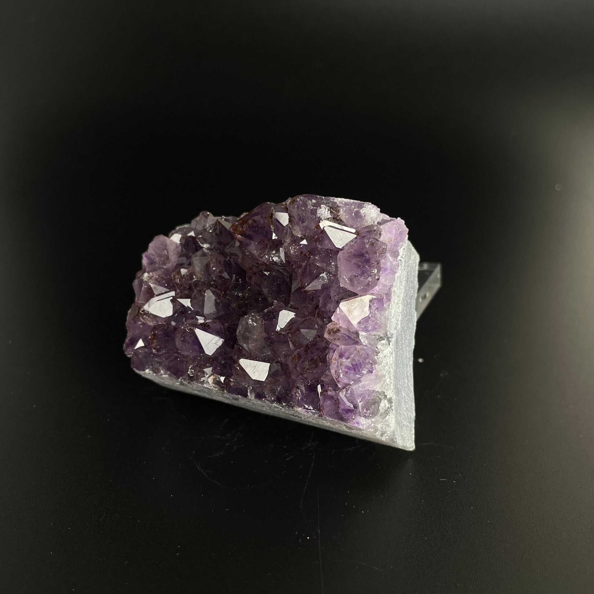 Amethyst cluster with brilliant hues of purple and various sizes of crystal formations.