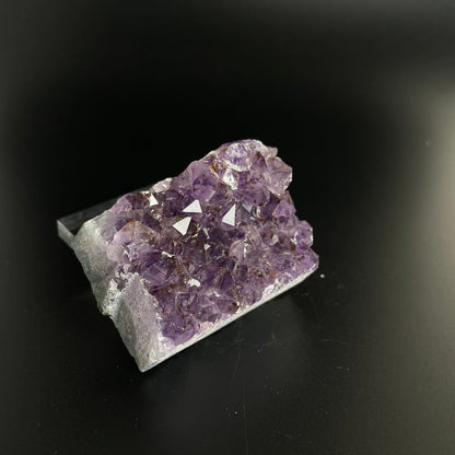 Amethyst cluster with brilliant hues of purple and various sizes of crystal formations.