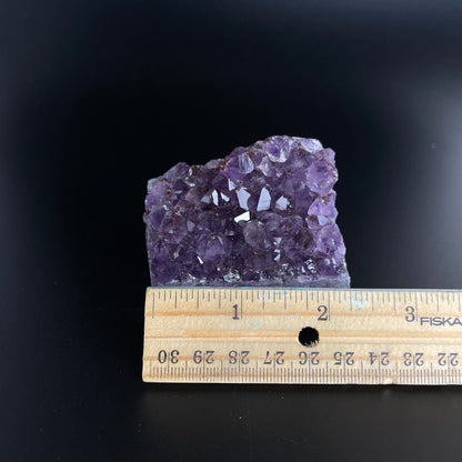 Amethyst cluster with brilliant hues of purple and various sizes of crystal formations.