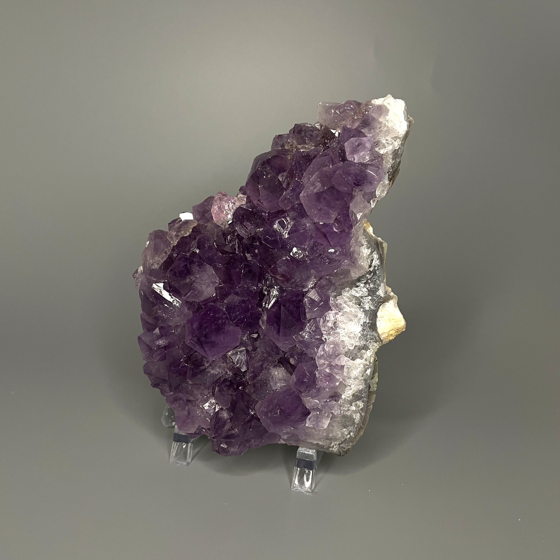 Amethyst cluster with brilliant hues of purple and various sizes of crystal formations.