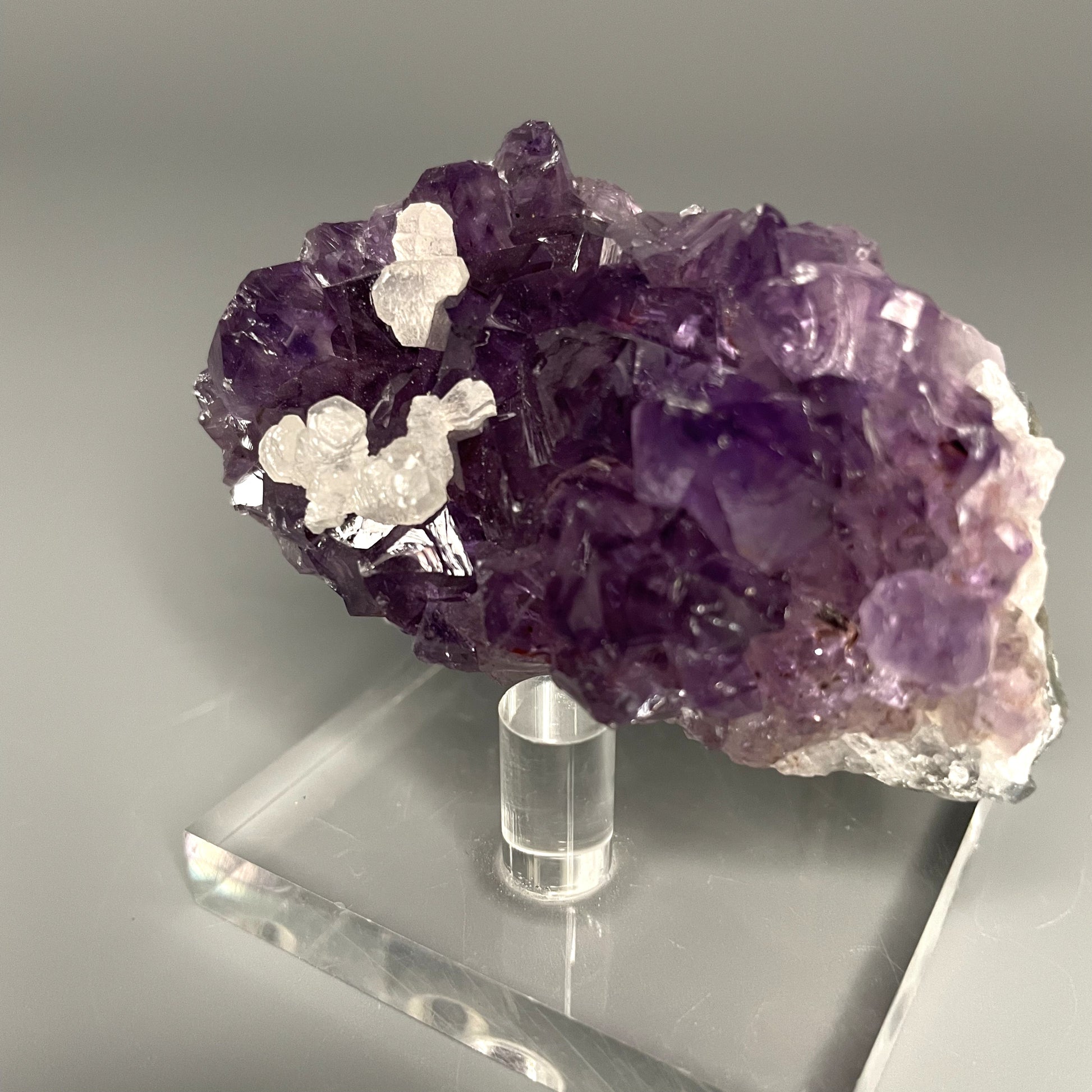 Amethyst cluster with brilliant hues of purple and various sizes of crystal formations.