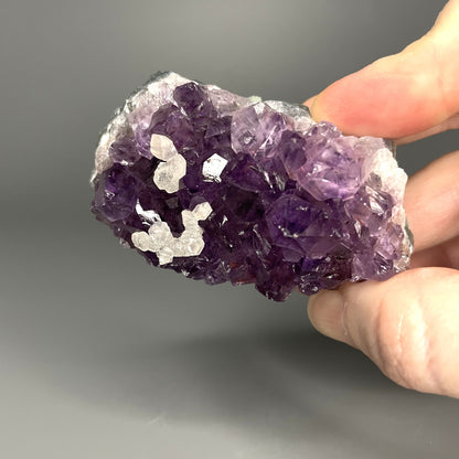 Amethyst cluster with brilliant hues of purple and various sizes of crystal formations.