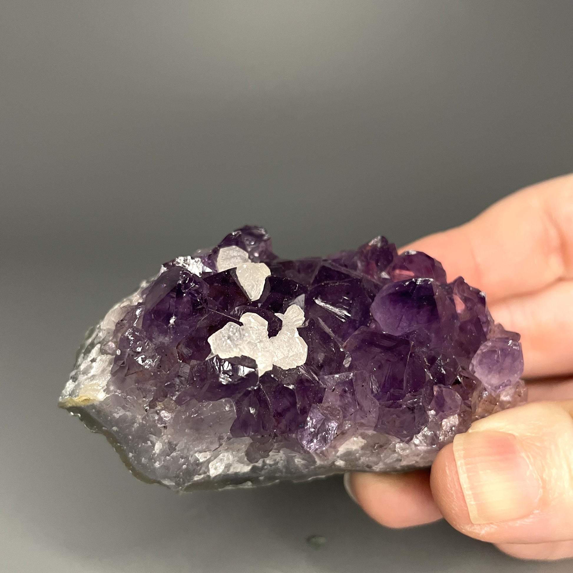 Amethyst cluster with brilliant hues of purple and various sizes of crystal formations.