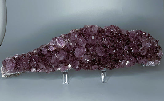 Amethyst cluster with brilliant hues of purple and various sizes of crystal formations.