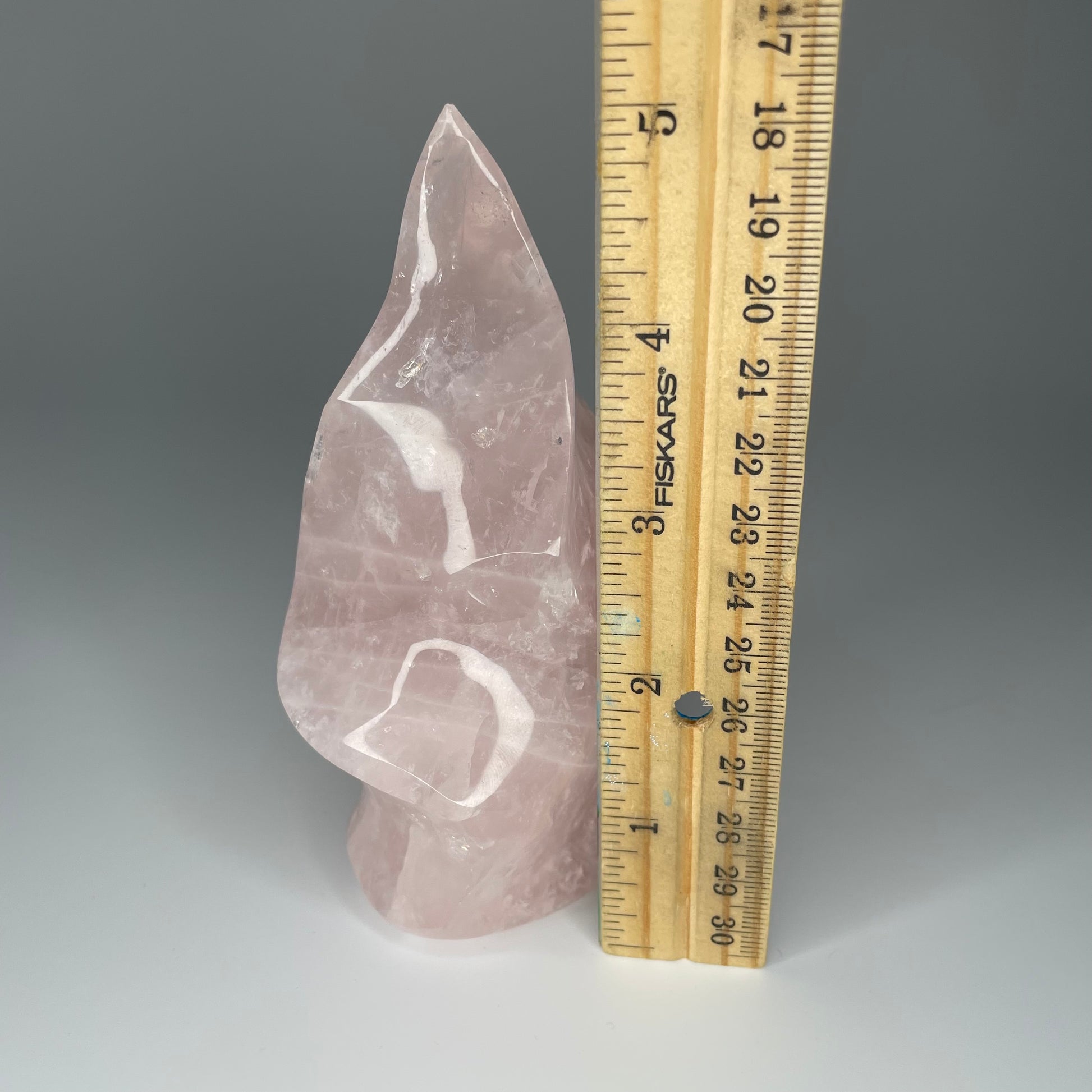 A 5-inch Rose Quartz Flame Carving with soft pink hues and a smooth, polished finish, shaped like a flickering flame, symbolizing love and transformation.