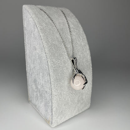 A 3 cm pendant featuring a detailed claw holding a tiny mineral sphere, available in various stones, hanging from a stainless steel chain.