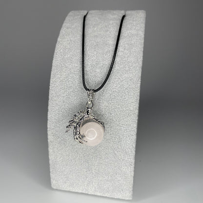 A 3 cm pendant featuring a detailed claw holding a tiny mineral sphere, available in various stones, hanging from a black nylon necklace.