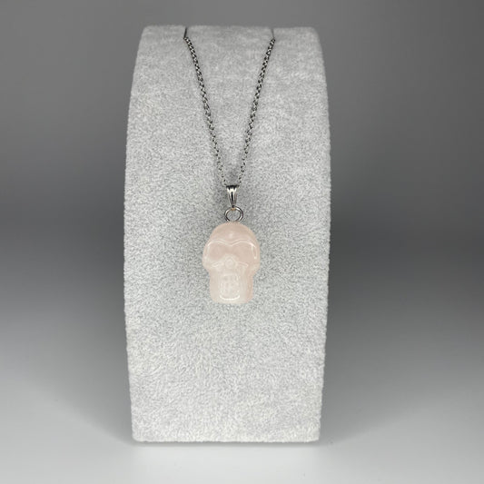 A 3 cm skull pendant carved from various minerals, symbolizing wisdom and transformation, with a stainless steel chain.