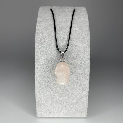 A 3 cm skull pendant carved from various minerals, symbolizing wisdom and transformation, with a black nylon necklace.