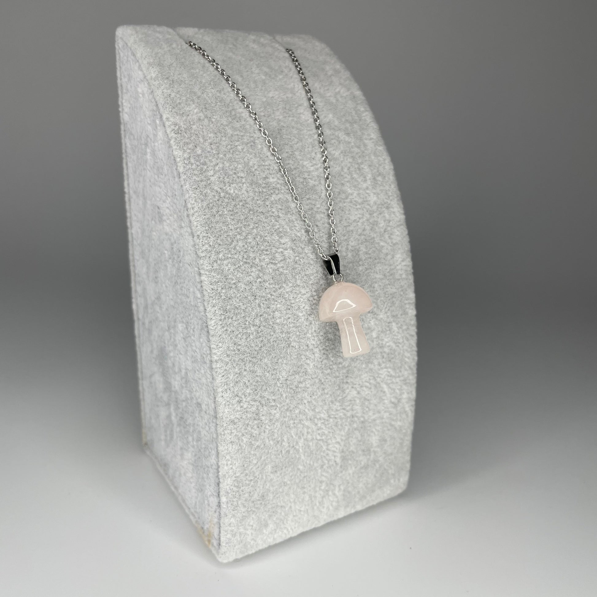 A 3 cm mushroom-shaped pendant carved from various minerals with a stainless steel chain or black nylon necklace.