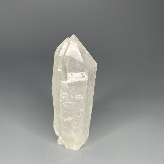 A 4.75-inch Clear Quartz double-point tower with a smooth, polished finish, standing upright against a neutral background.