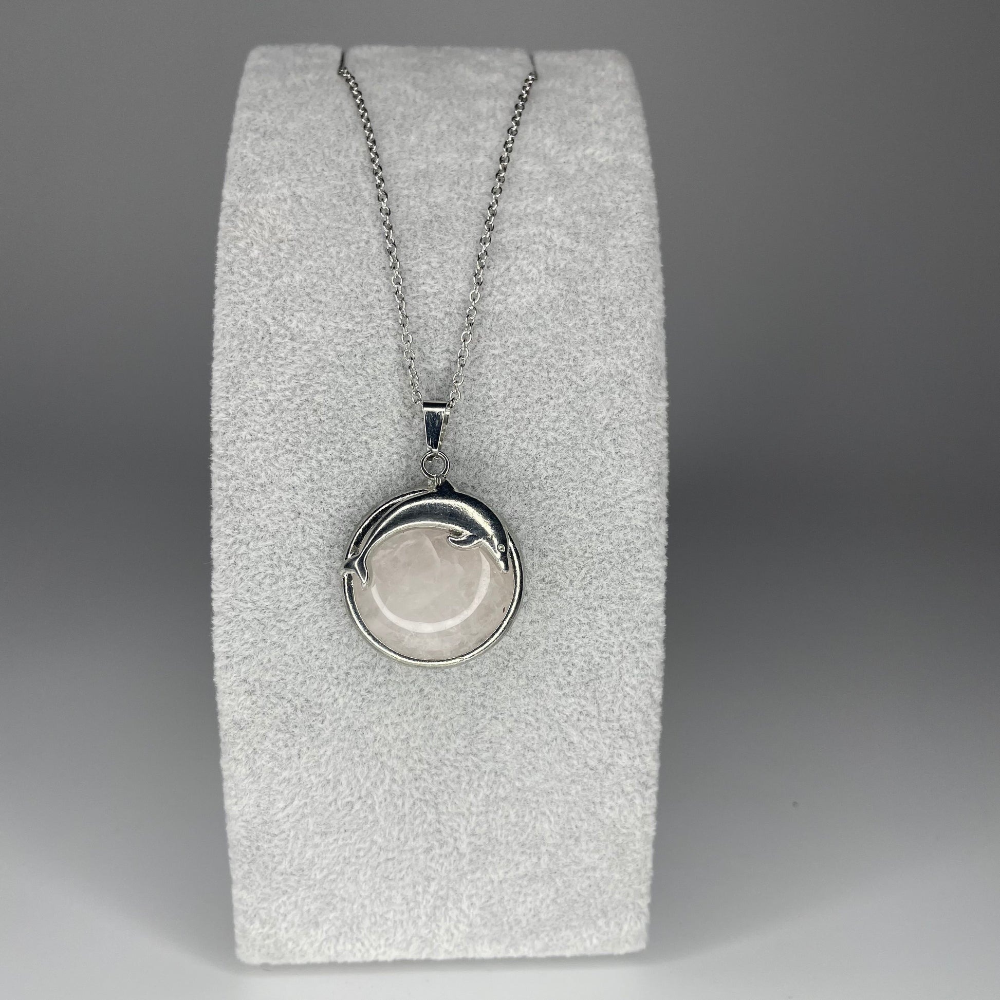 A 3 cm cabochon pendant featuring a dolphin design on a polished stone, available in various minerals, with a stainless steel chain.