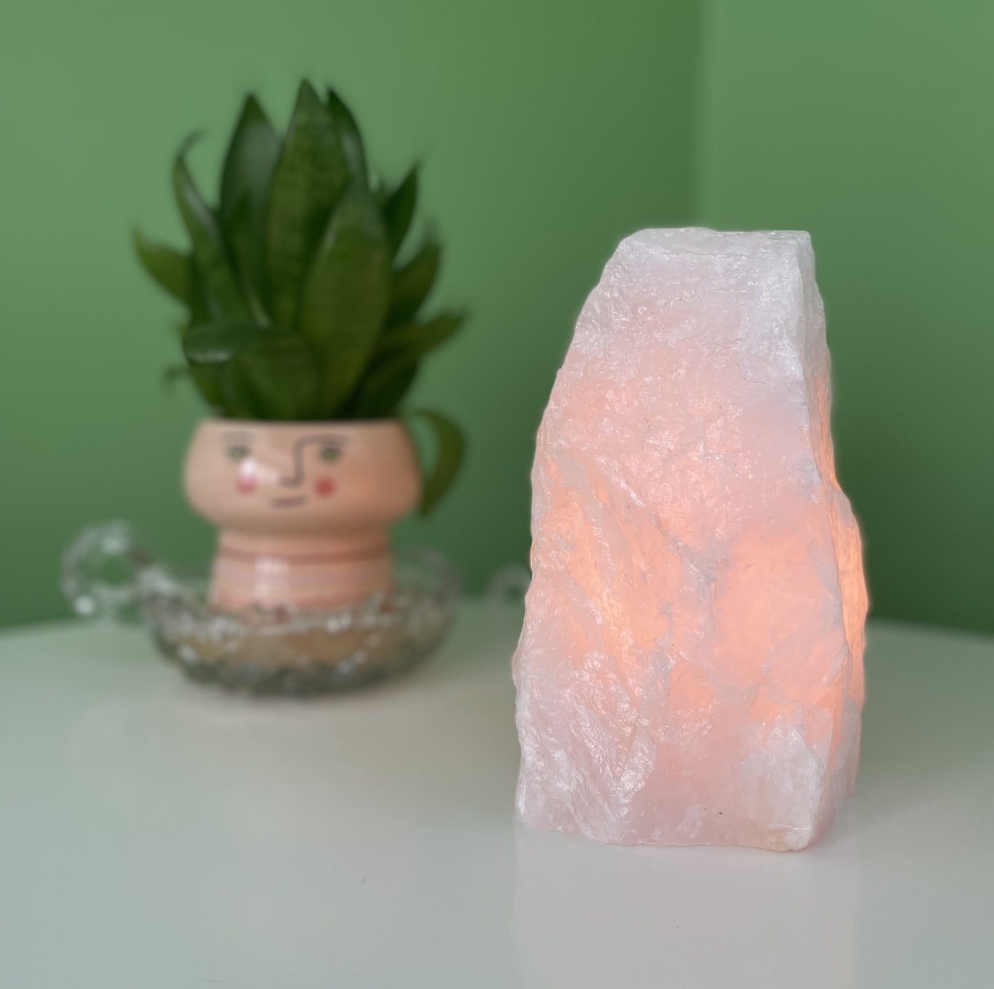 A glowing Rose Quartz Mineral Lamp with soft pink hues.