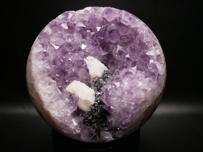 Large amethyst sphere with internal quartz druze on a black background.