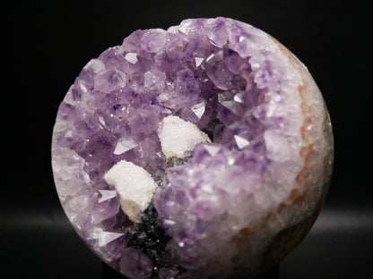 Large amethyst sphere with internal quartz druze on a black background.