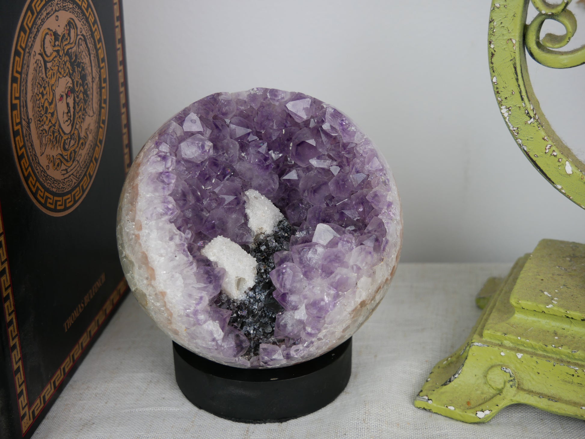 Large amethyst sphere with internal quartz druze on a neutral background.