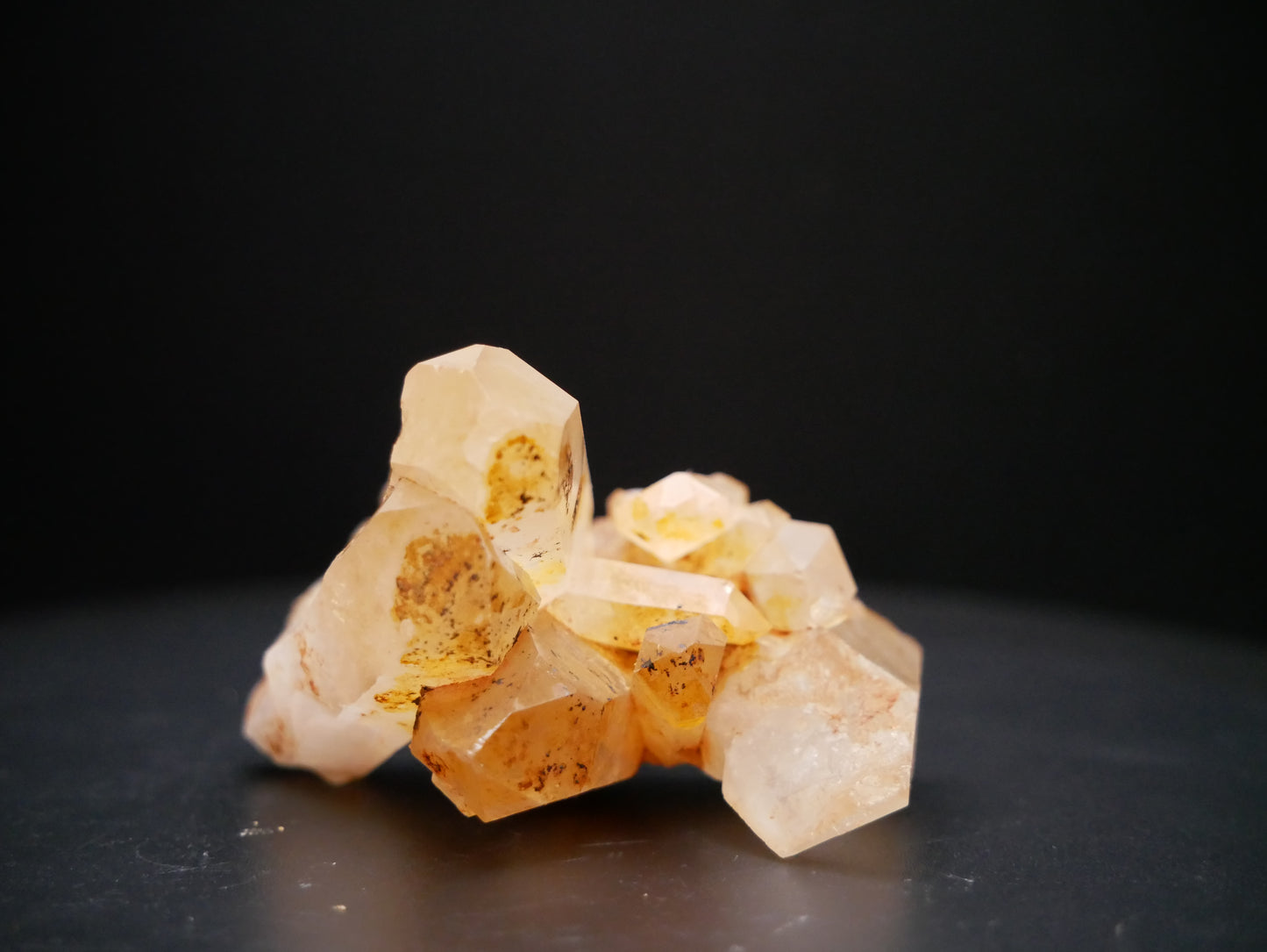 A 56-gram tangerine quartz cluster with distinctive peach-colored crystal formations on a black background.