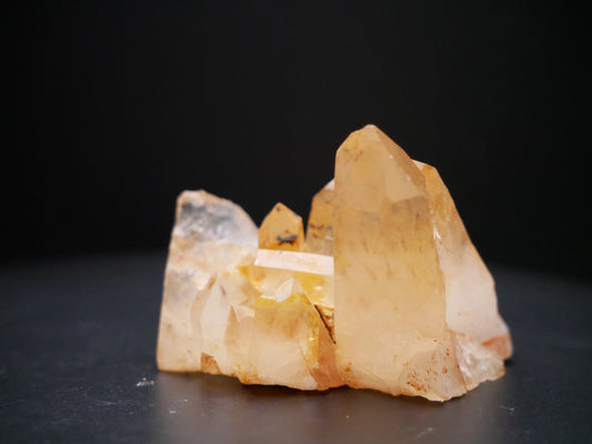 A 56-gram tangerine quartz cluster with distinctive peach-colored crystal formations on a black background.