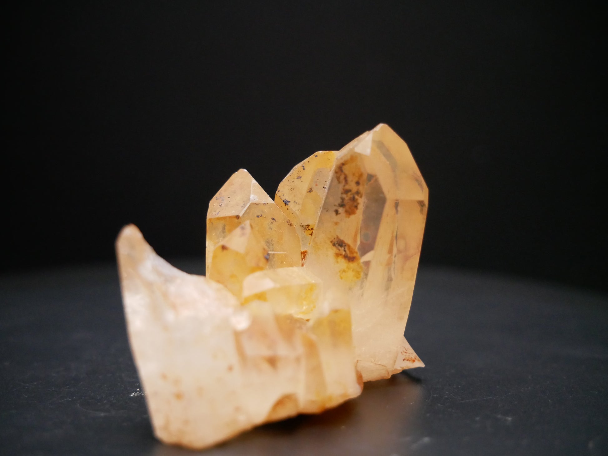 A 56-gram tangerine quartz cluster with distinctive peach-colored crystal formations on a black background.