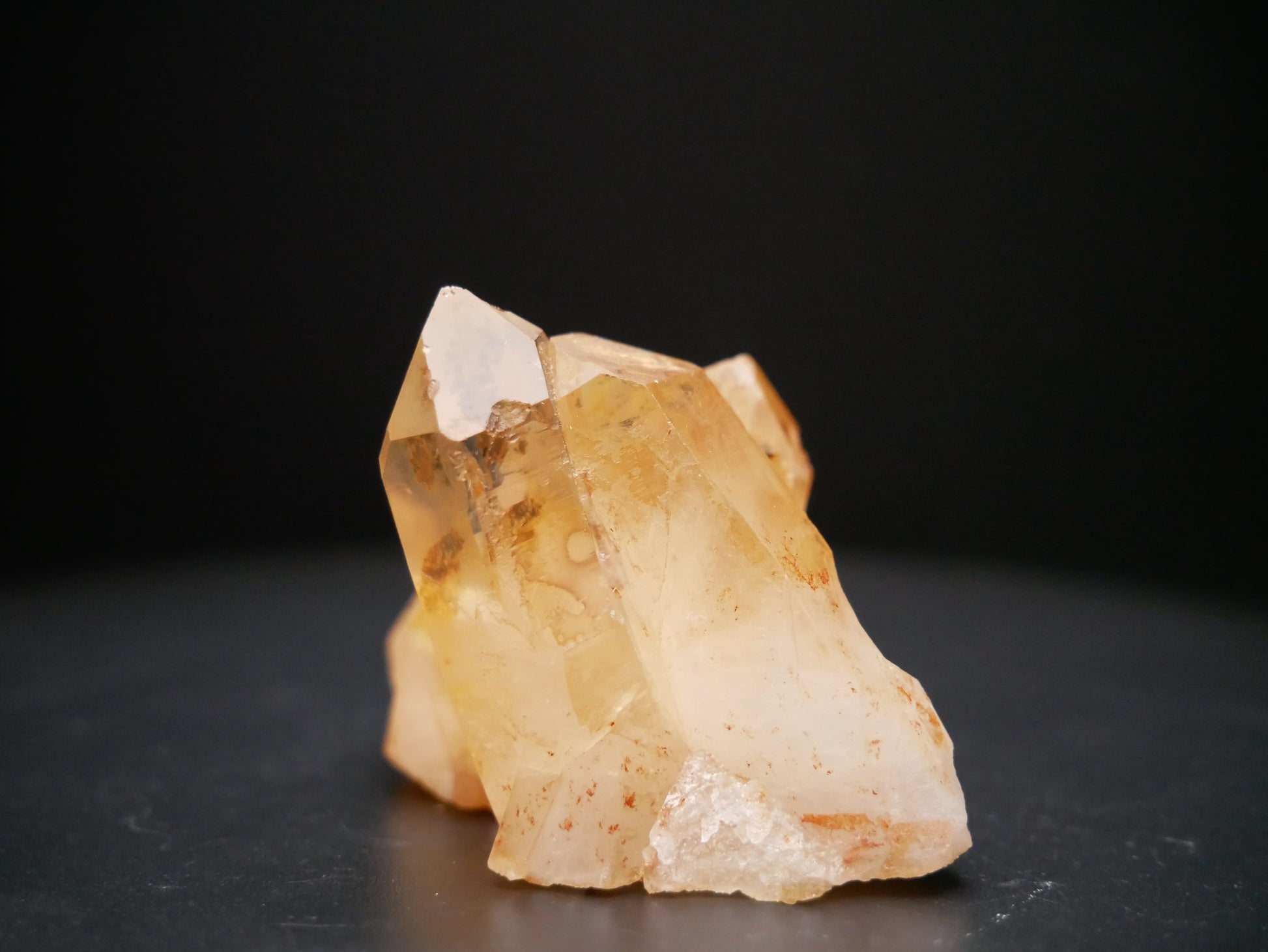 A 56-gram tangerine quartz cluster with distinctive peach-colored crystal formations on a black background.