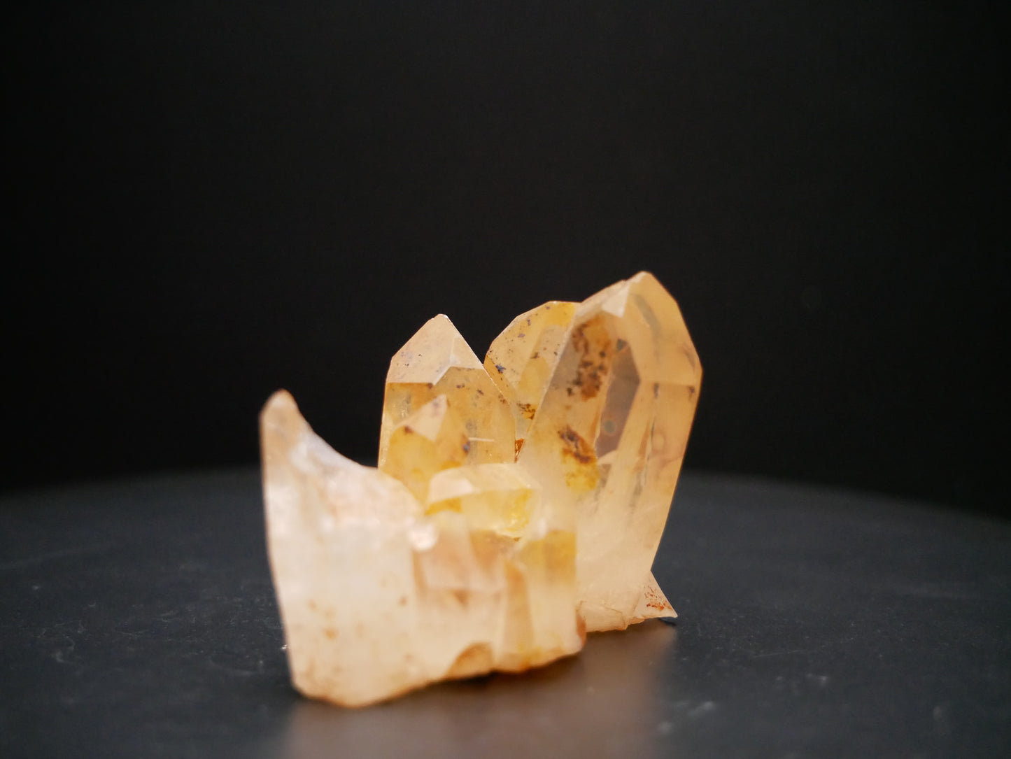 A 56-gram tangerine quartz cluster with distinctive peach-colored crystal formations on a black background.