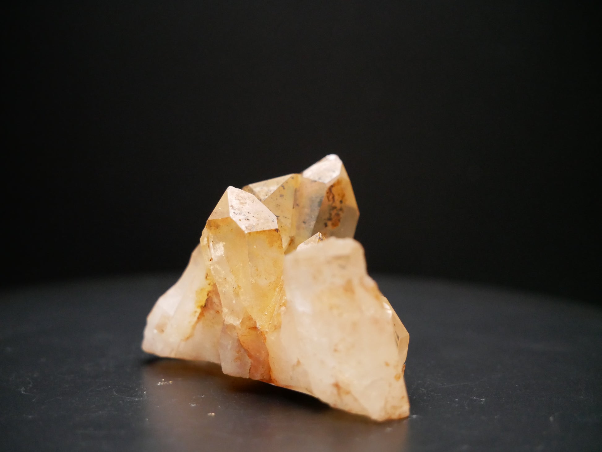 A 56-gram tangerine quartz cluster with distinctive peach-colored crystal formations on a black background.