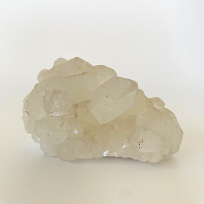 A 3-inch clear apophyllite cluster with distinctive crystal formations on a white background.