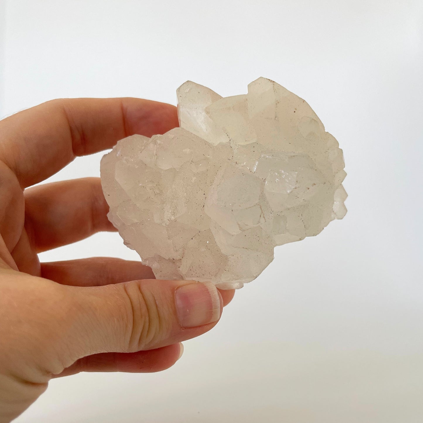 A 3-inch clear apophyllite cluster with distinctive crystal formations on a white background.